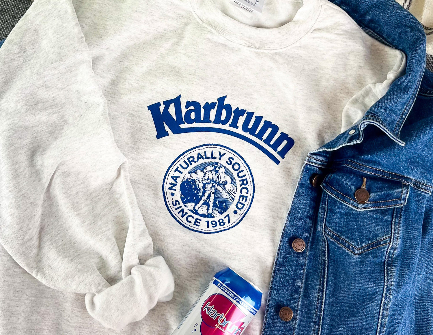 sweater with retro klarbrunn under jean jacket with can of klarbrunn on top