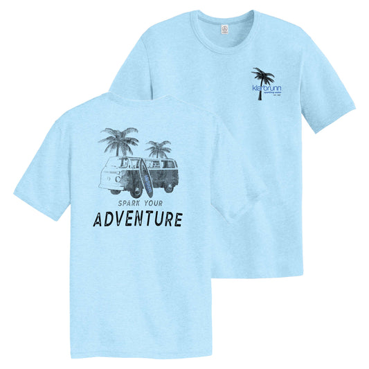 light blue shirt. back design with van, palm trees and words "spark your adventure". front has "klarbrunn" in front of palm tree